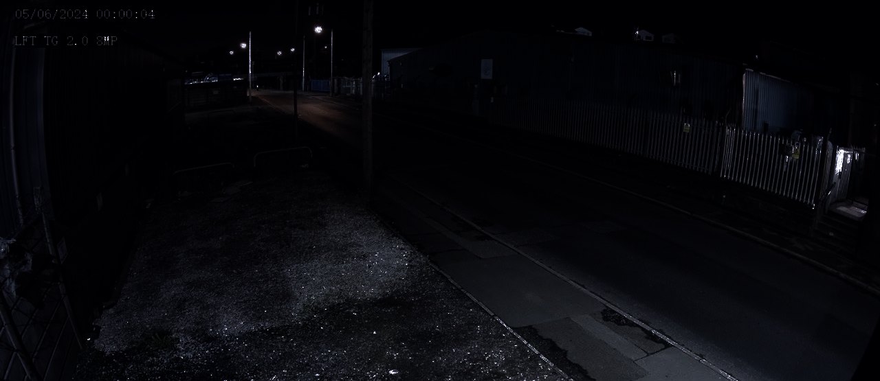 The same street at night as it looks to the naked eye: very dark